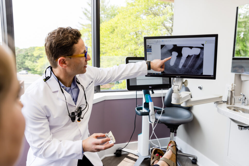 Dentist explaining to a patient how dental implants in Fairfax work.